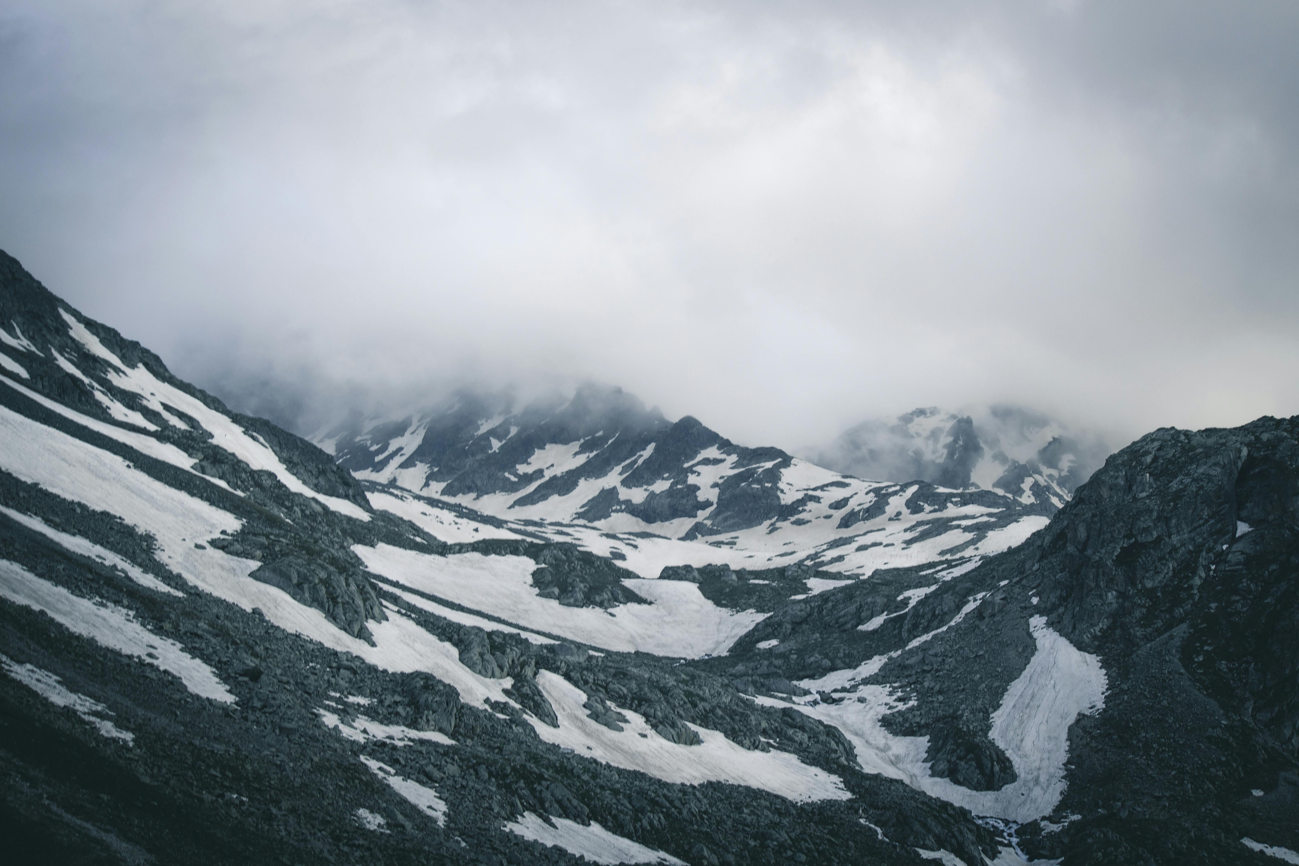 Ein Bild von vielen Bergen mit Schnee und Nebenl in einem Bildslider