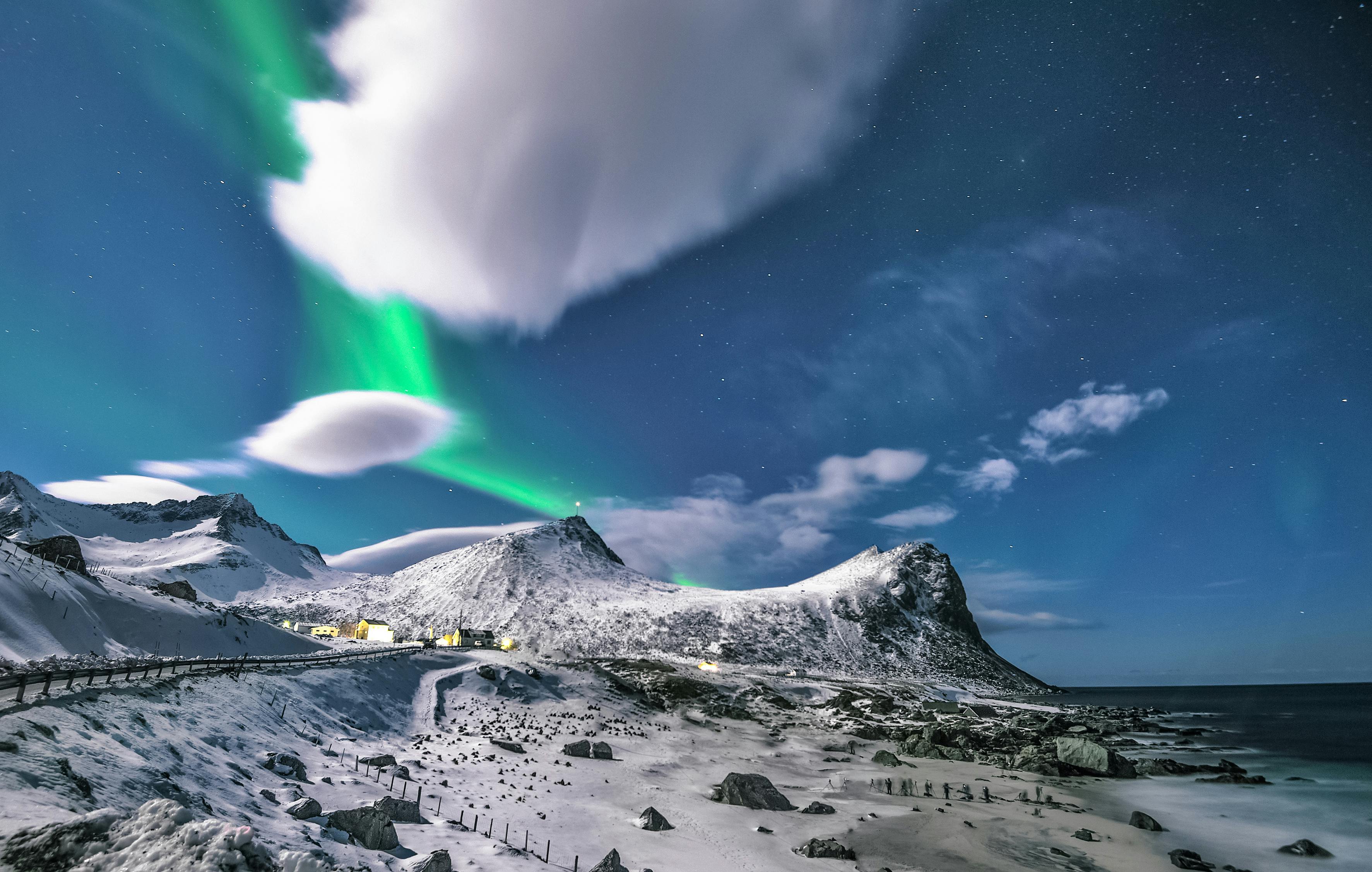 Ein Bild von einem Berg mit Polarlichtern in einem Bildslider